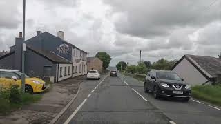 road through village with cloudy sky