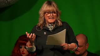 a woman on stage reading from paper