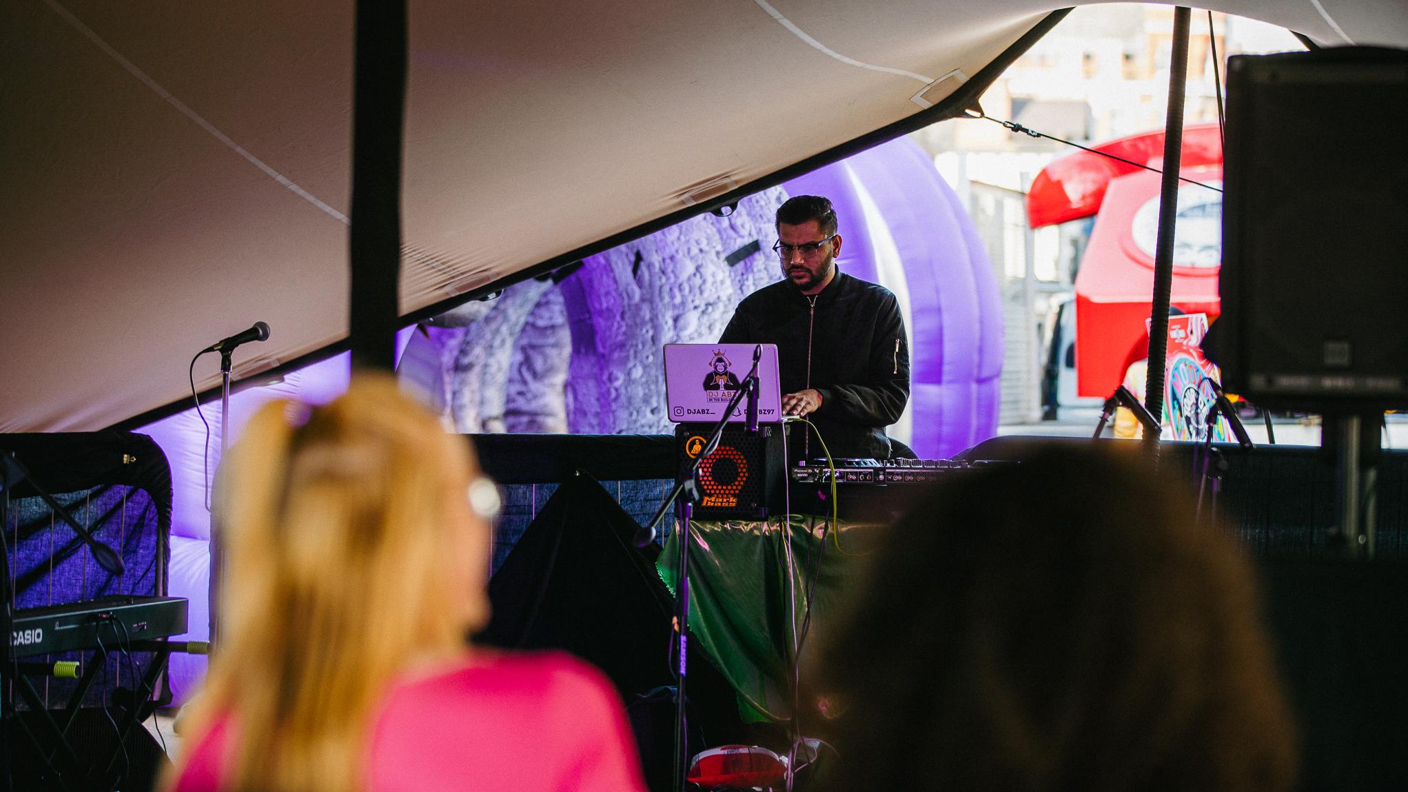 man DJing inside tent