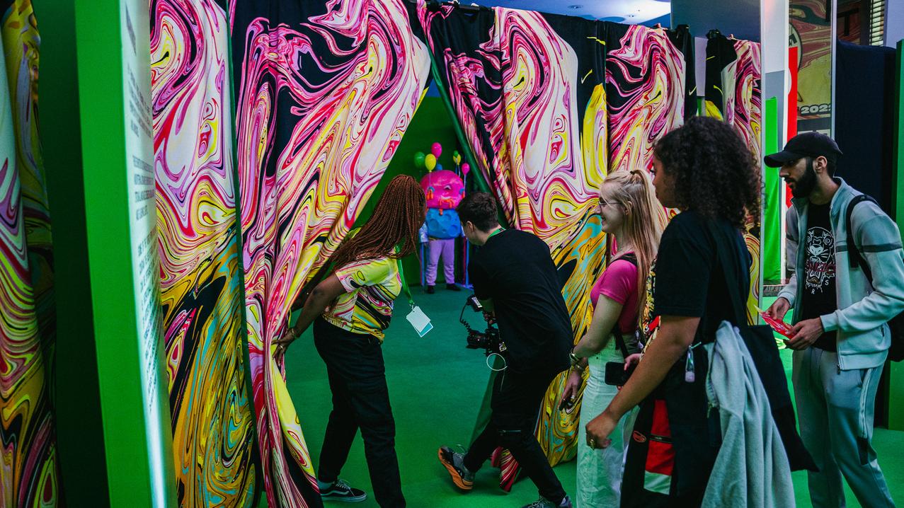 a crowd enters moon experiences through a curtain